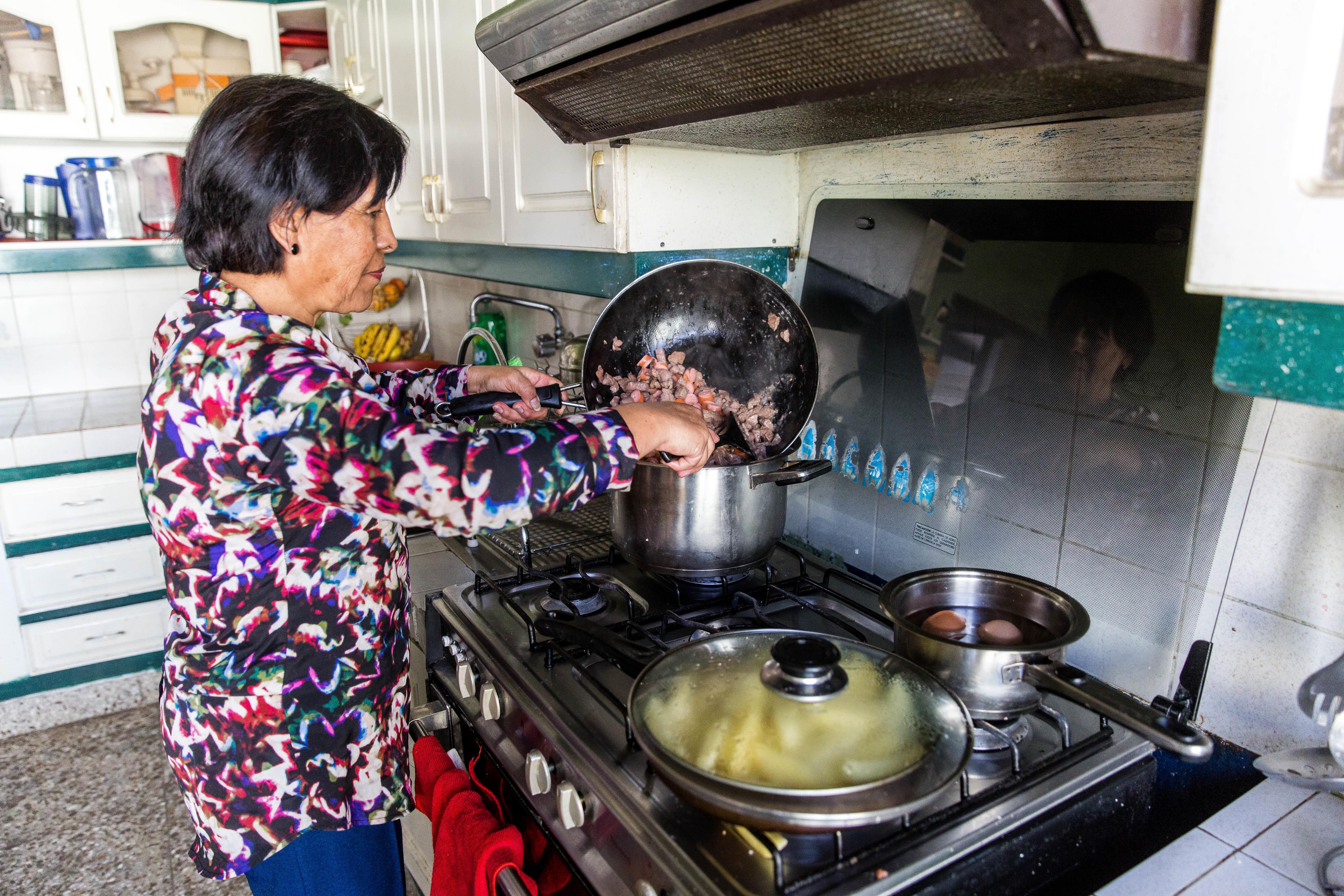 A host mother cooks a traditional meal at a Projects Abroad host family home. A host mother cooks for Projects Abroad volunteers at their host family accommodation abroad.